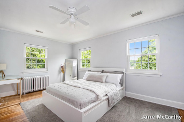 1101 Cadillac Dr SE, Grand Rapids, MI 49506 - bedroom with radiator heating unit, ornamental molding, wood finished floors, and a ceiling fan