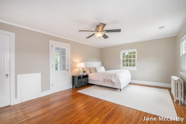 1101 Cadillac Dr SE, Grand Rapids, MI 49506 - bedroom with radiator, wood finished floors, crown molding, and ceiling fan