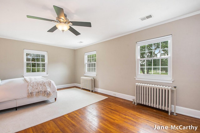 1101 Cadillac Dr SE, Grand Rapids, MI 49506 - bedroom featuring radiator, wood finished floors, crown molding, and ceiling fan