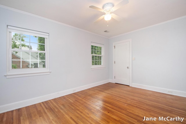 1101 Cadillac Dr SE, Grand Rapids, MI 49506 - spare room featuring healthy amount of natural light, light wood-type flooring, ornamental molding, and a ceiling fan