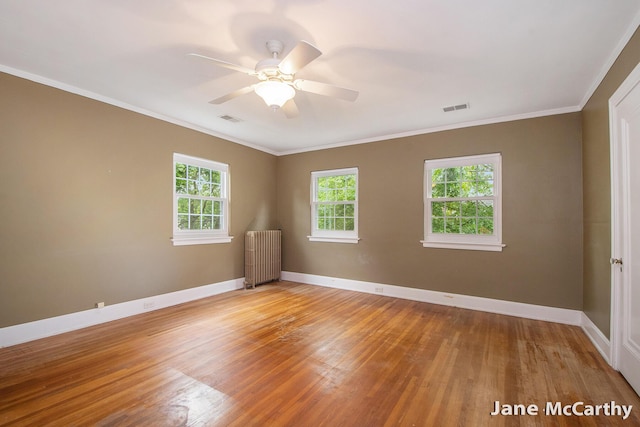 1101 Cadillac Dr SE, Grand Rapids, MI 49506 - spare room with radiator, light wood-style flooring, a ceiling fan, and crown molding