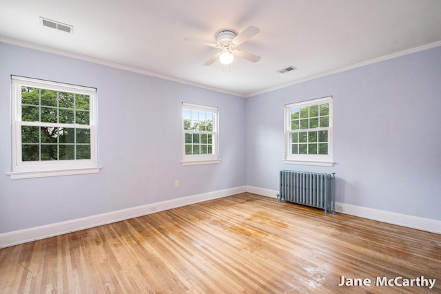 1101 Cadillac Dr SE, Grand Rapids, MI 49506 - spare room featuring radiator, healthy amount of natural light, a ceiling fan, crown molding, and light wood-type flooring