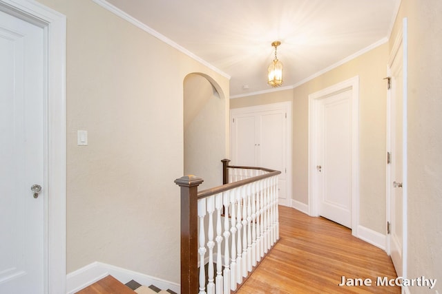 1101 Cadillac Dr SE, Grand Rapids, MI 49506 - hallway featuring an upstairs landing, light wood-style flooring, and crown molding