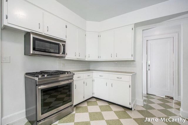 1101 Cadillac Dr SE, Grand Rapids, MI 49506 - kitchen with stainless steel appliances, light floors, light countertops, and white cabinetry
