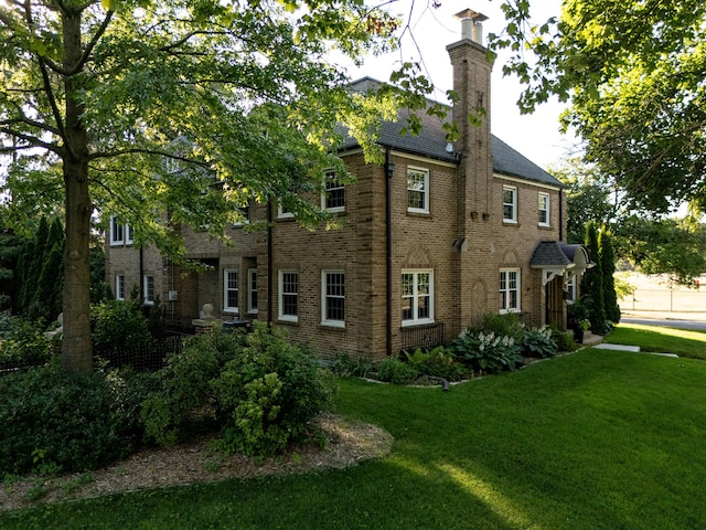 1101 Cadillac Dr SE, Grand Rapids, MI 49506 - view of property exterior with a lawn, a chimney, and brick siding