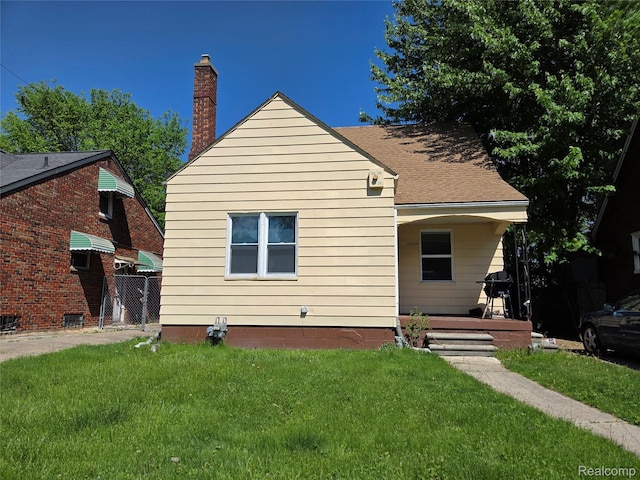 20200 Greeley St, Detroit, MI 48203 - rear view of house with a lawn, a chimney, and covered porch