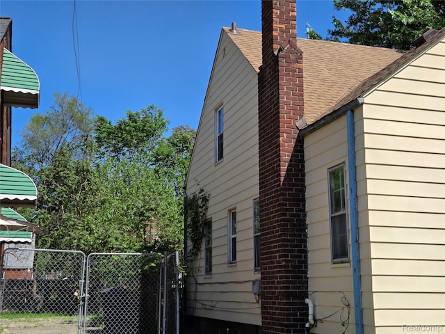 20200 Greeley St, Detroit, MI 48203 - view of property exterior with roof with shingles, a chimney, and a gate