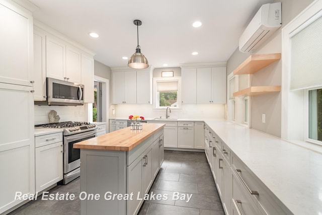 34 E Hannum Blvd, Saginaw, MI 48602 - kitchen with wooden counters, appliances with stainless steel finishes, a wall unit AC, backsplash, and recessed lighting
