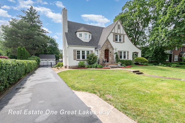 34 E Hannum Blvd, Saginaw, MI 48602 - tudor home featuring stone siding, stucco siding, a front lawn, and a chimney