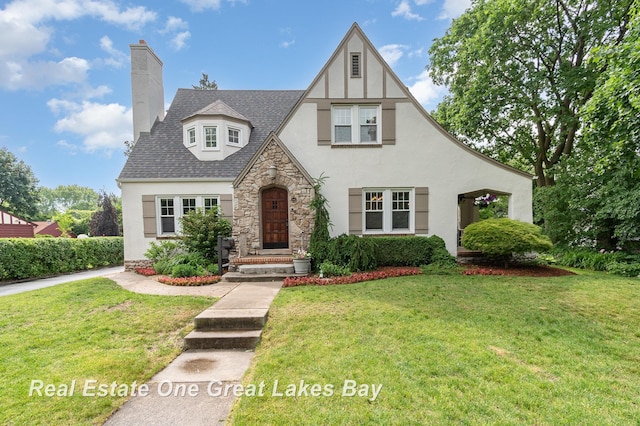 34 E Hannum Blvd, Saginaw, MI 48602 - english style home with stucco siding, stone siding, and a front lawn