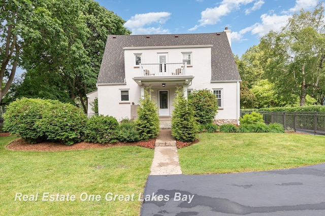 34 E Hannum Blvd, Saginaw, MI 48602 - view of front of home with a balcony, stucco siding, a chimney, and roof with shingles