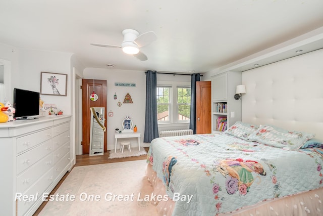 34 E Hannum Blvd, Saginaw, MI 48602 - bedroom with radiator, wood finished floors, and a ceiling fan
