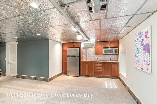34 E Hannum Blvd, Saginaw, MI 48602 - kitchen featuring appliances with stainless steel finishes, brown cabinetry, an ornate ceiling, light colored carpet, and backsplash