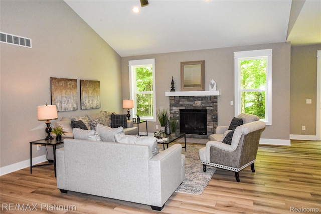 74 Candlelight, Brighton, MI 48114 - living room with wood finished floors, lofted ceiling, a stone fireplace, and recessed lighting