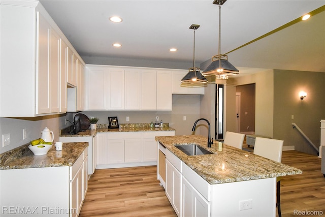 74 Candlelight, Brighton, MI 48114 - kitchen featuring light wood-style flooring, white cabinets, a center island with sink, recessed lighting, and pendant lighting