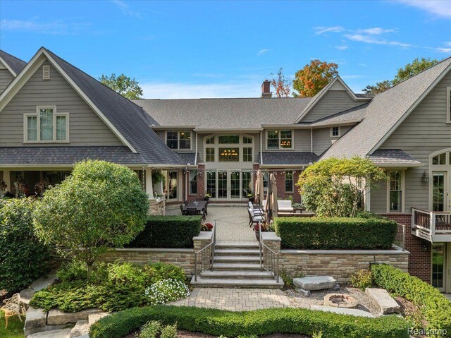 1330 Oxford Rd, Bloomfield Hills, MI 48304 - view of front of home featuring a chimney, brick siding, a shingled roof, and a patio
