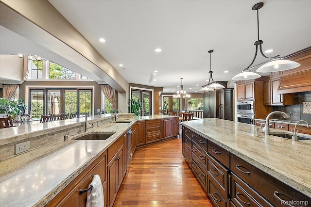1330 Oxford Rd, Bloomfield Hills, MI 48304 - kitchen with plenty of natural light, recessed lighting, light stone countertops, wood-type flooring, and a chandelier
