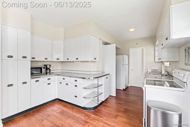 1226 W Genesee St, Lapeer, MI 48446 - kitchen with freestanding refrigerator, stainless steel microwave, washer / clothes dryer, wood finished floors, and white cabinets