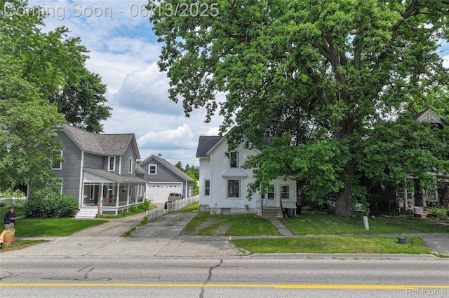 1226 W Genesee St, Lapeer, MI 48446 - view of front of property with a front lawn, concrete driveway, entry steps, and an outbuilding
