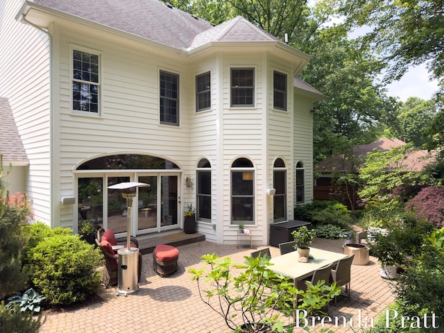 5691 Forest Gln SE, Ada, MI 49301 - rear view of house featuring a patio area, a shingled roof, and outdoor dining area