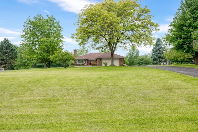 9128 Clover Dr, Milan, MI 48160 - view of green lawn featuring a garage and driveway