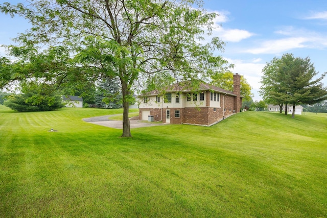 9128 Clover Dr, Milan, MI 48160 - view of grassy yard featuring concrete driveway and an attached garage