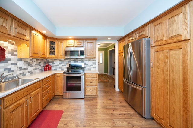 9128 Clover Dr, Milan, MI 48160 - kitchen featuring stainless steel appliances, light wood-type flooring, light countertops, decorative backsplash, and glass insert cabinets