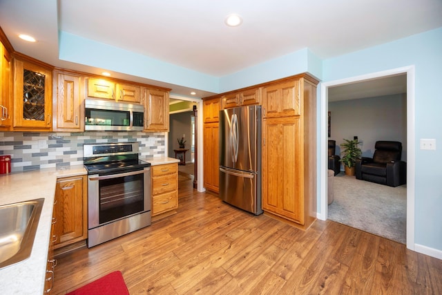 9128 Clover Dr, Milan, MI 48160 - kitchen with appliances with stainless steel finishes, light countertops, tasteful backsplash, recessed lighting, and light wood finished floors