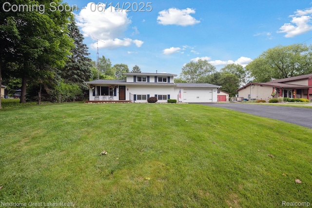 4098 Sam Snead Dr, Flint, MI 48506 - split level home featuring asphalt driveway, a front lawn, an attached garage, and a sunroom