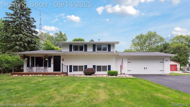 4098 Sam Snead Dr, Flint, MI 48506 - split level home featuring a porch, a garage, a front lawn, and asphalt driveway