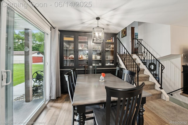 4098 Sam Snead Dr, Flint, MI 48506 - dining space featuring stairs, light wood-type flooring, and a chandelier