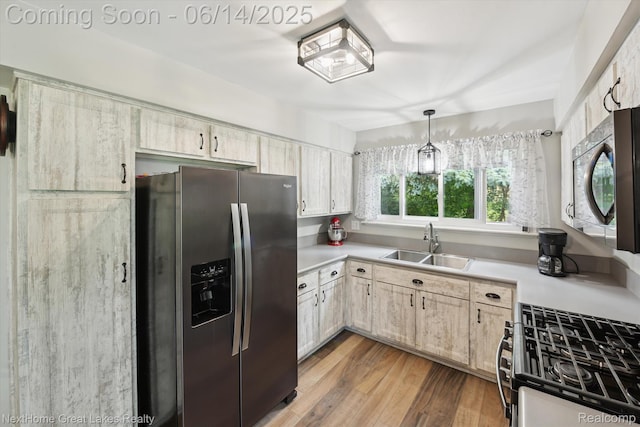 4098 Sam Snead Dr, Flint, MI 48506 - kitchen featuring stainless steel appliances, light countertops, light wood finished floors, and hanging light fixtures