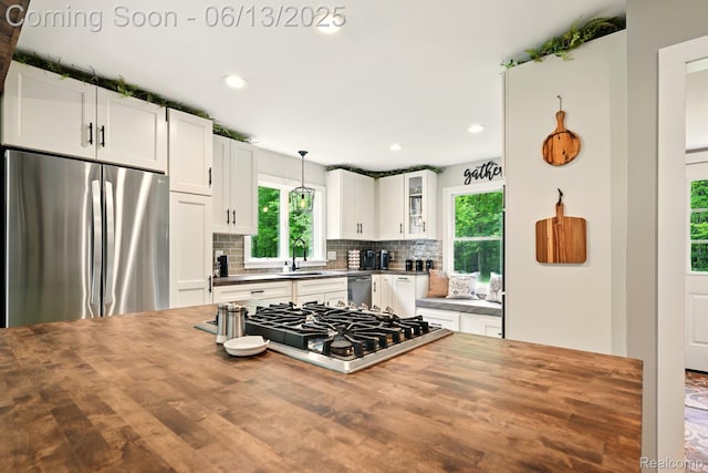 6535 Cedar Lake Rd, Pinckney, MI 48169 - kitchen with appliances with stainless steel finishes, butcher block countertops, backsplash, glass insert cabinets, and recessed lighting