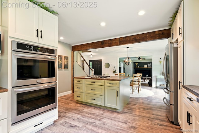 6535 Cedar Lake Rd, Pinckney, MI 48169 - kitchen featuring stainless steel appliances, butcher block countertops, green cabinetry, light wood-type flooring, and a ceiling fan