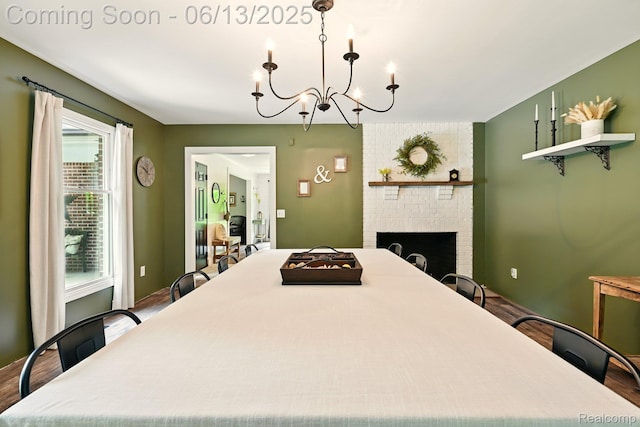 6535 Cedar Lake Rd, Pinckney, MI 48169 - dining space featuring a chandelier, wood finished floors, and a brick fireplace