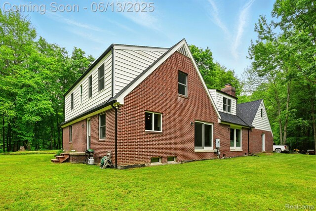 6535 Cedar Lake Rd, Pinckney, MI 48169 - rear view of house featuring brick siding, a yard, and a chimney