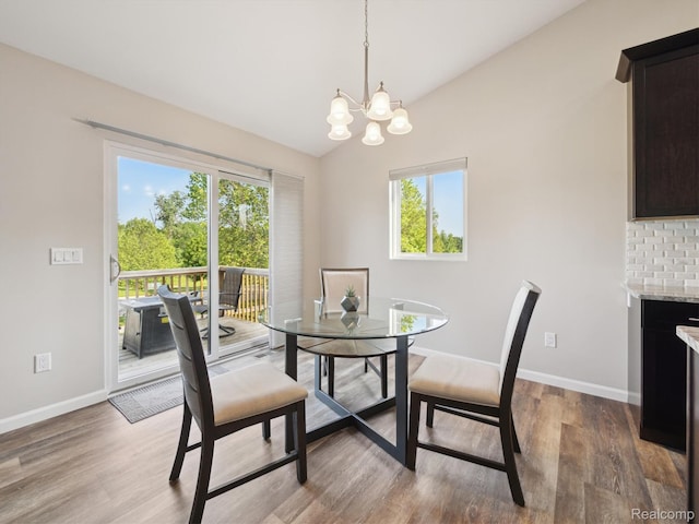 1470 Duncan Dr, Chelsea, MI 48118 - dining space with healthy amount of natural light, a chandelier, wood finished floors, and lofted ceiling