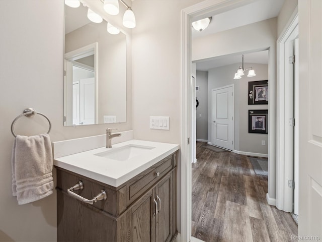 1470 Duncan Dr, Chelsea, MI 48118 - bathroom with wood finished floors, vanity, and a chandelier