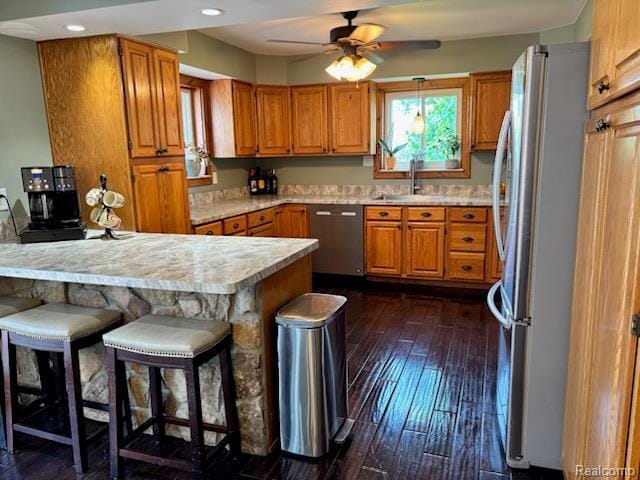 3985 Wadhams Rd, China, MI 48054 - kitchen with appliances with stainless steel finishes, a peninsula, light countertops, brown cabinetry, and recessed lighting