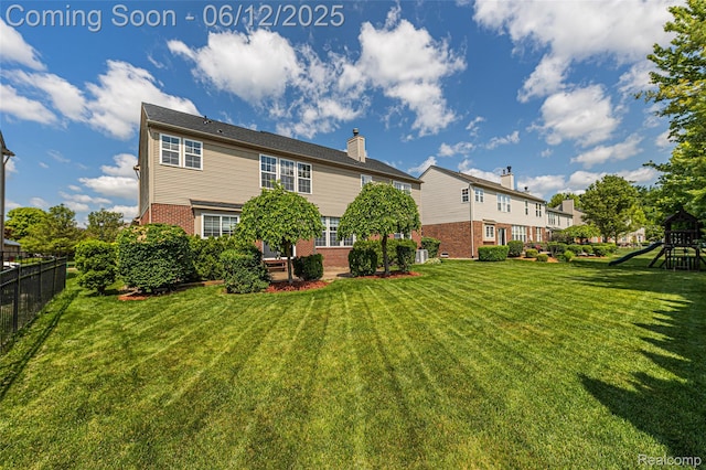 49620 Dunhill Dr, Macomb, MI 48044 - rear view of house featuring a playground, brick siding, and a chimney