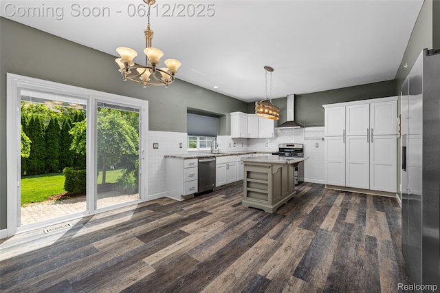 49620 Dunhill Dr, Macomb, MI 48044 - kitchen with appliances with stainless steel finishes, wall chimney exhaust hood, a chandelier, dark wood finished floors, and white cabinets