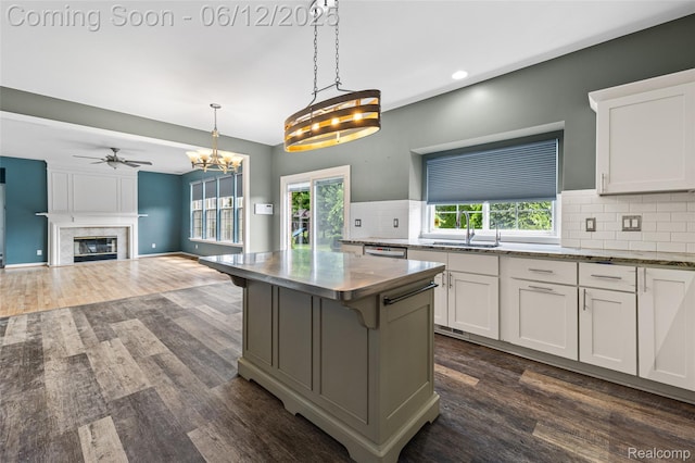 49620 Dunhill Dr, Macomb, MI 48044 - kitchen with dark wood-style floors, backsplash, a fireplace, white cabinetry, and ceiling fan