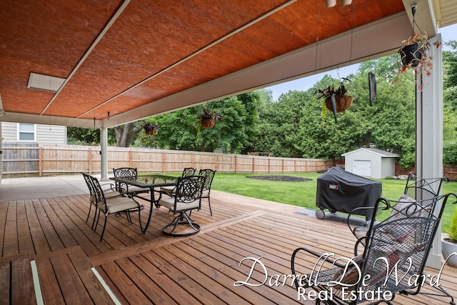 6662 Adaridge Dr SE, Ada, MI 49301 - deck with a fenced backyard, outdoor dining area, grilling area, and a storage unit