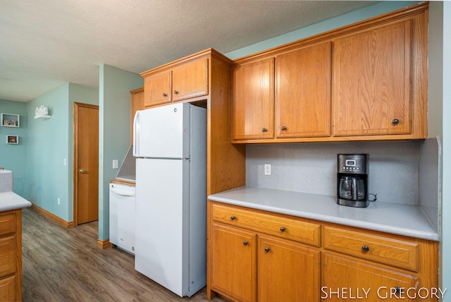 5151 Scotch Mist Dr, Saranac, MI 48881 - kitchen with white appliances, dark wood-style flooring, brown cabinets, light countertops, and a textured ceiling