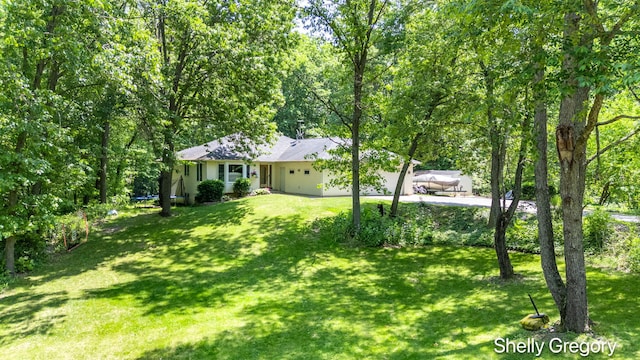 5151 Scotch Mist Dr, Saranac, MI 48881 - view of green lawn with a garage and driveway
