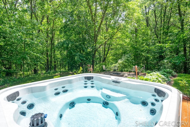 5151 Scotch Mist Dr, Saranac, MI 48881 - view of swimming pool with a hot tub and a forest view