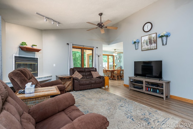 5151 Scotch Mist Dr, Saranac, MI 48881 - living room with ceiling fan, wood finished floors, track lighting, vaulted ceiling, and baseboard heating
