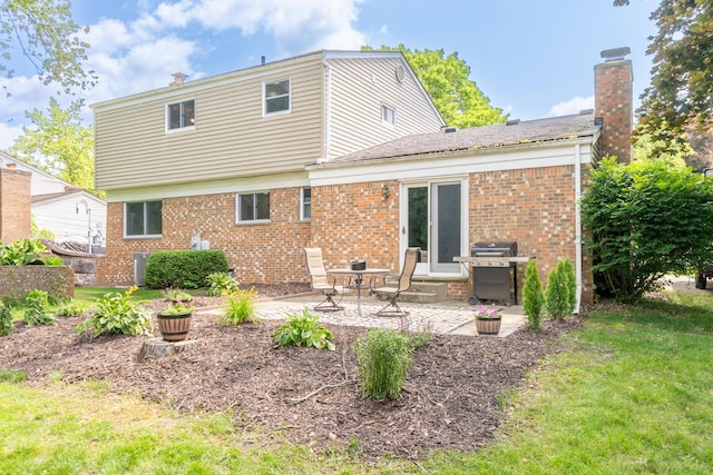 680 Eastlook Dr, Saline, MI 48176 - rear view of house with brick siding, a patio area, a chimney, and a yard