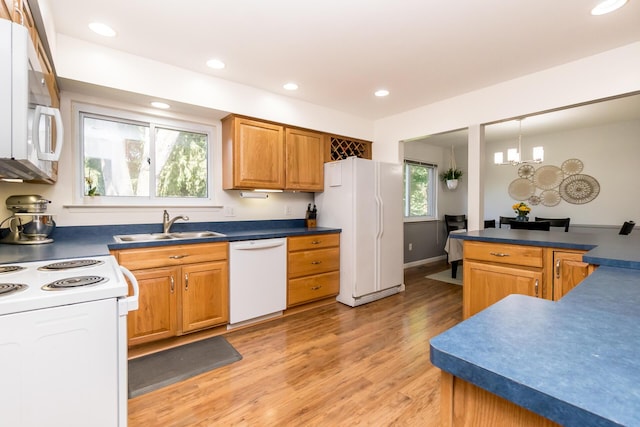680 Eastlook Dr, Saline, MI 48176 - kitchen with white appliances, light wood-style flooring, dark countertops, brown cabinetry, and recessed lighting