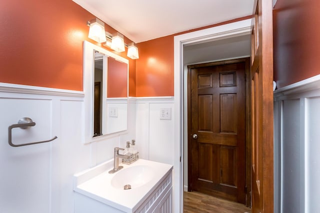 680 Eastlook Dr, Saline, MI 48176 - bathroom featuring vanity, a decorative wall, wainscoting, and wood finished floors